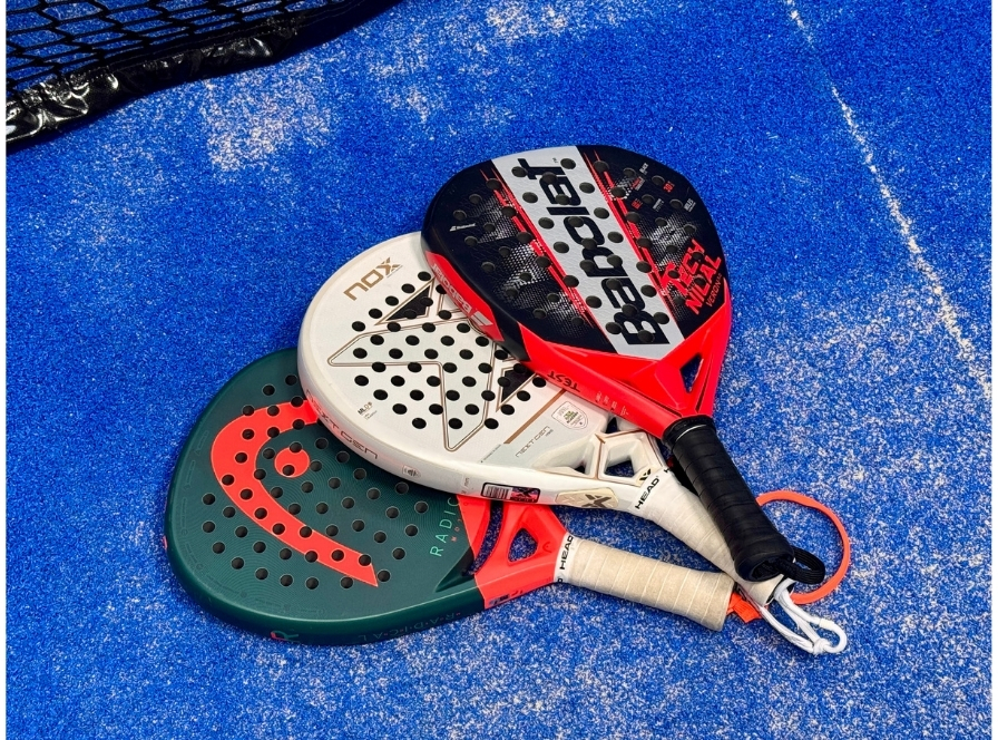 Tre padelracketar staplade på banan: HEAD Radical, NOX och Babolat – bäst i test för spelare på mellannivå