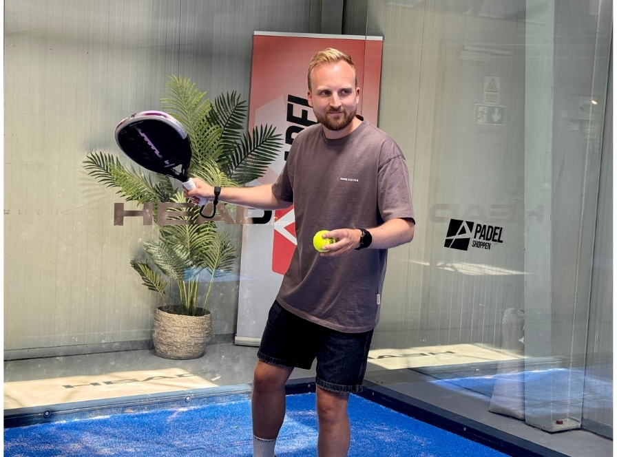 Padelspelare håller racket och boll redo att testa utrustning för avancerade spelare